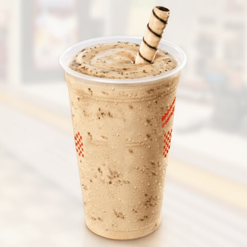 Um milk-shake com um canudo e um copo de sorvete.